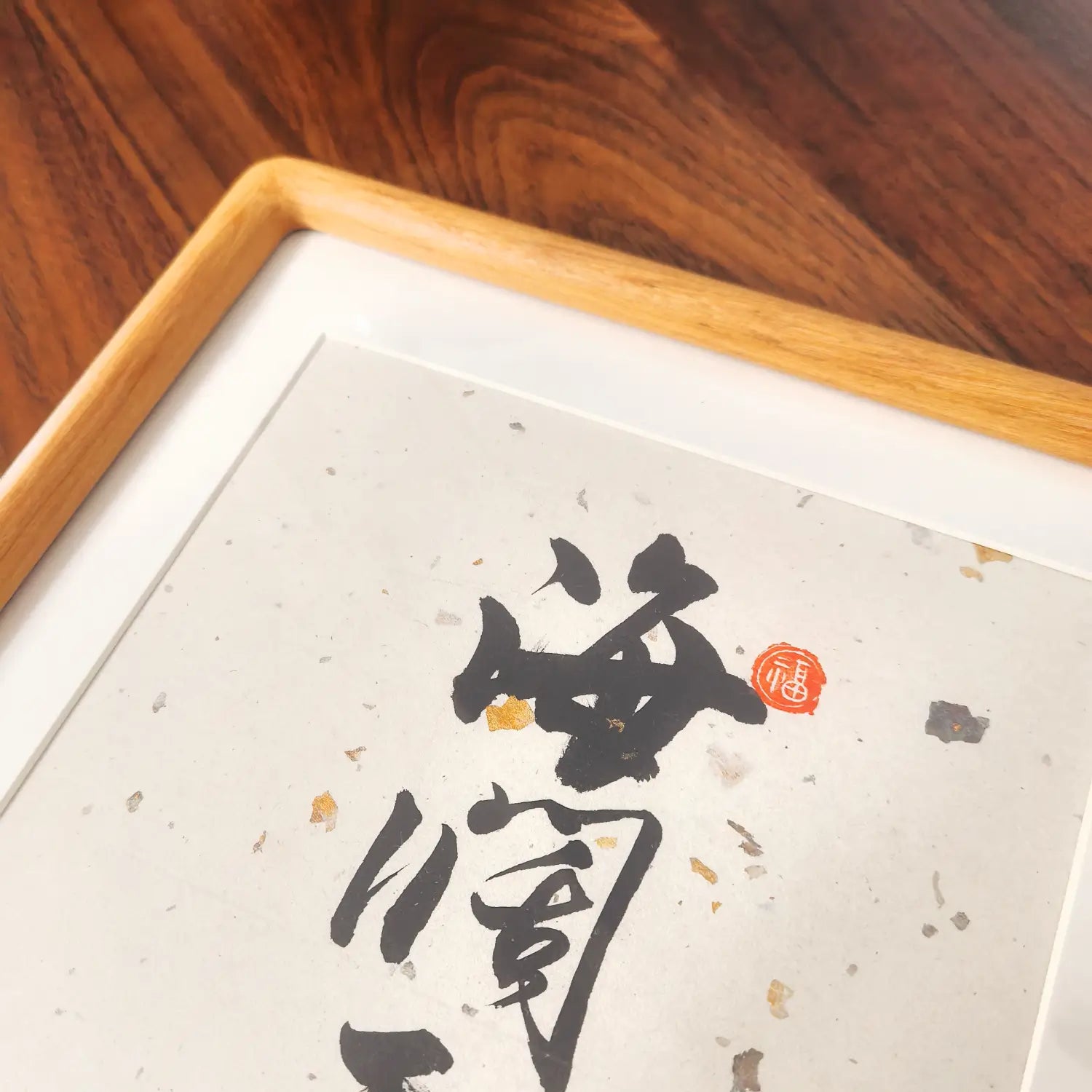 Framed calligraphy artwork on a wooden surface, Minimalist black ink Chinese wall art
