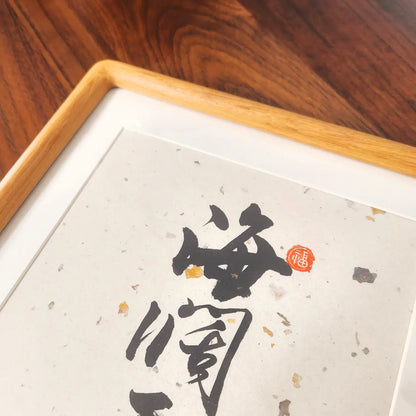 Framed calligraphy artwork on a wooden surface, Minimalist black ink Chinese wall art
