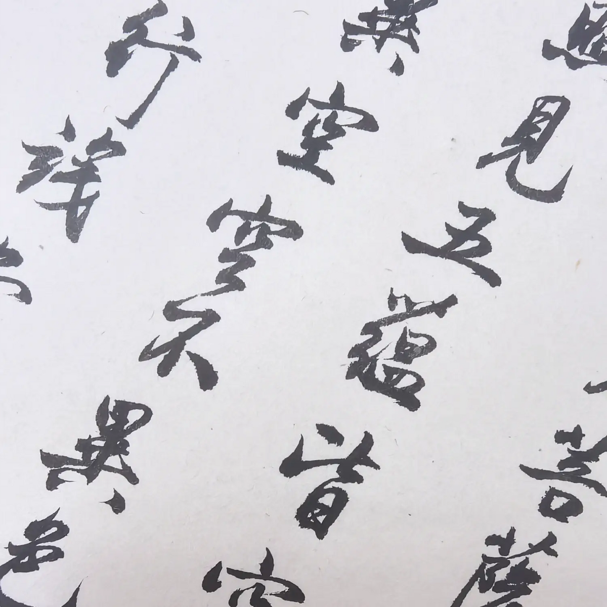 Close-up of handwritten Heart Sutra Chinese calligraphy in black ink on traditional Chinese calligraphy paper.