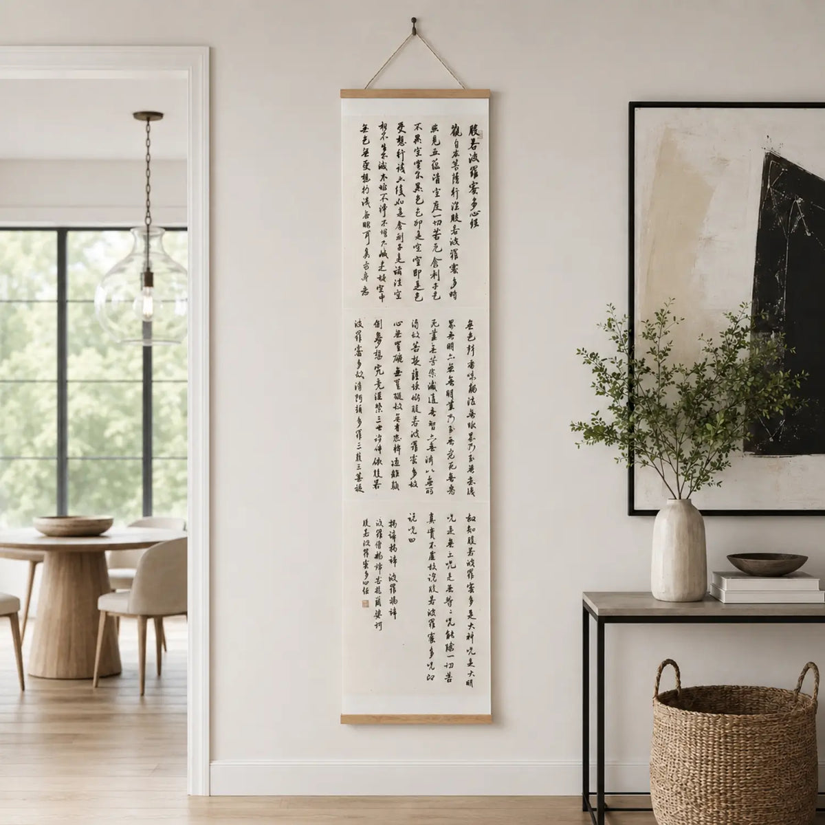 Handwritten Heart Sutra Chinese calligraphy hanging scroll with teak rods, displayed on a minimal white wall.