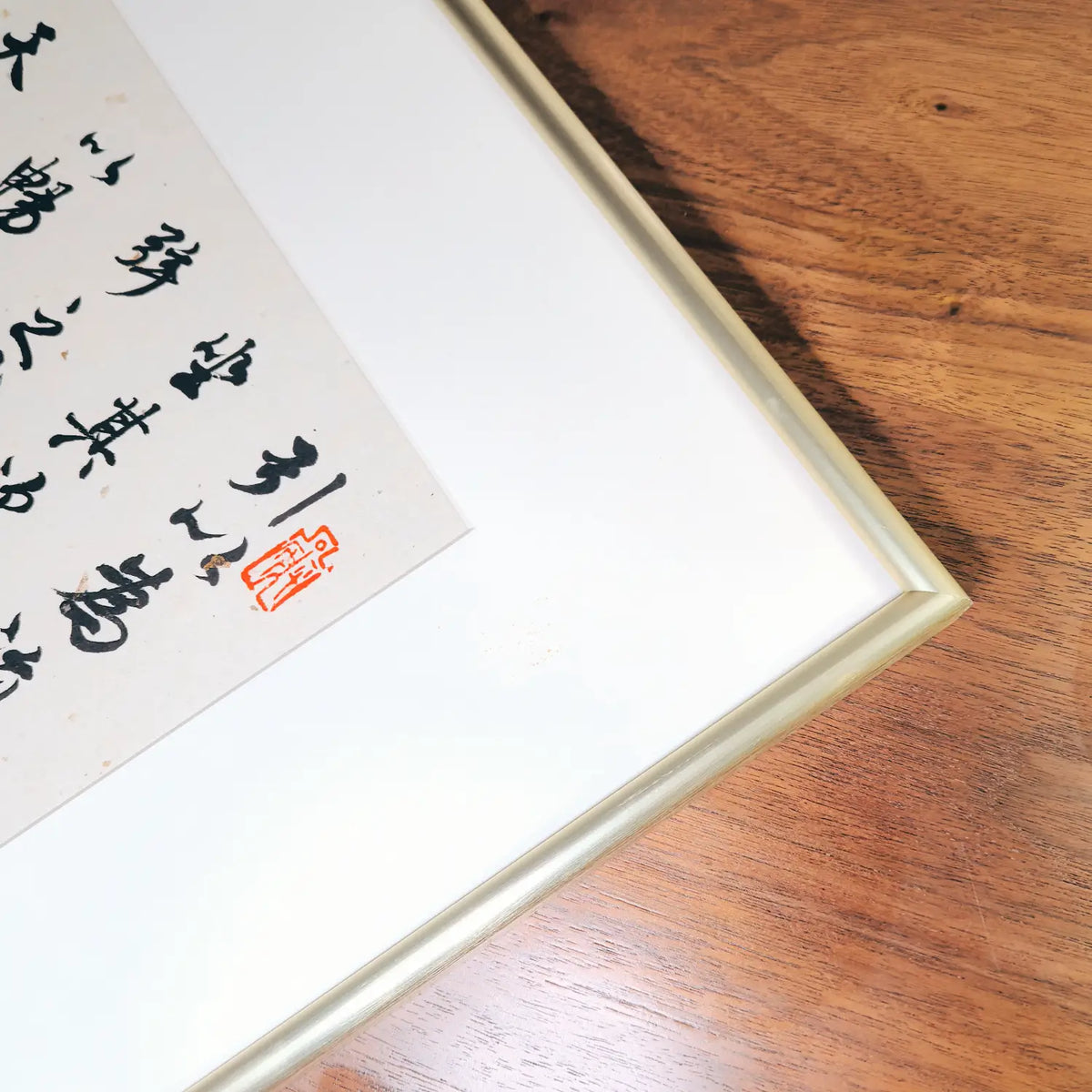 close shot of handwritten Chinese calligraphy wall art gold framed decor