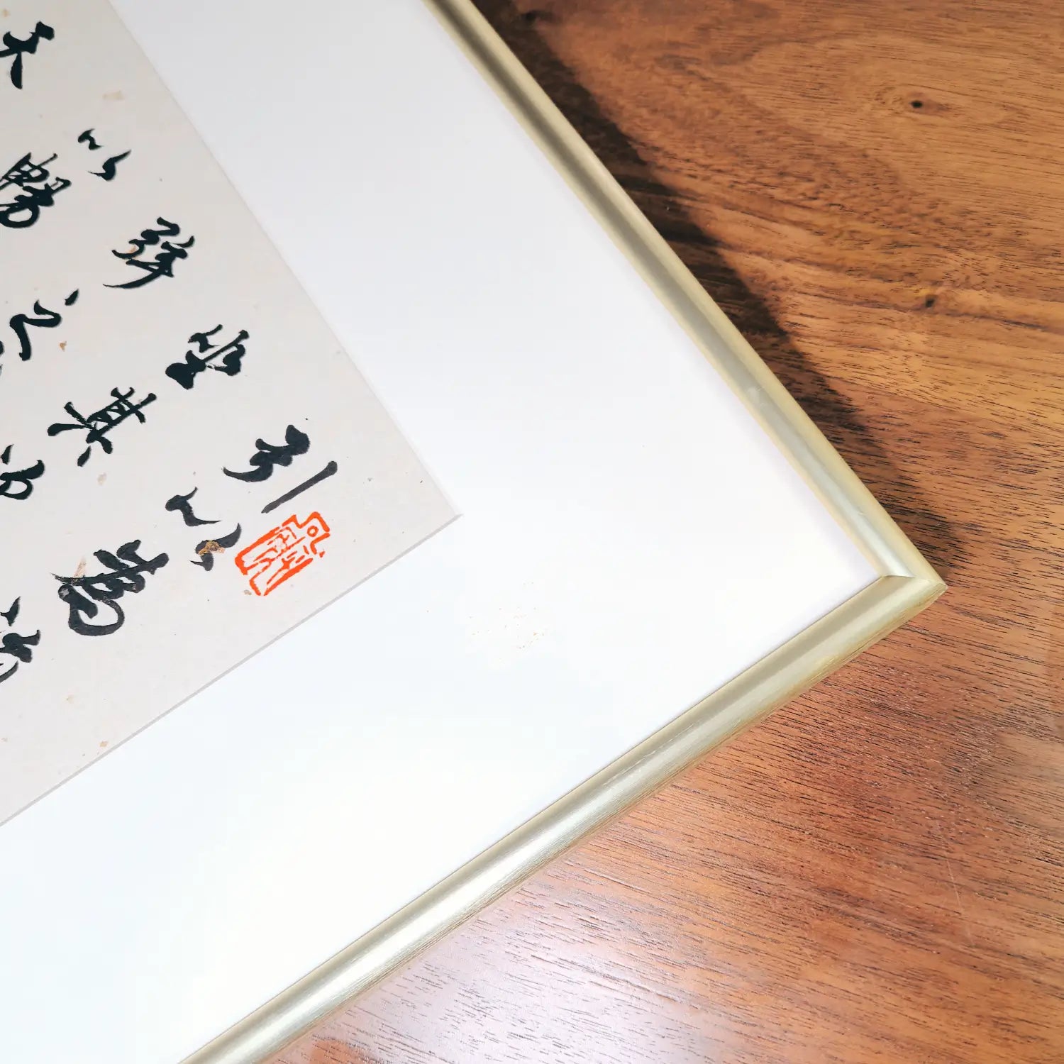 close shot of handwritten Chinese calligraphy wall art gold framed decor