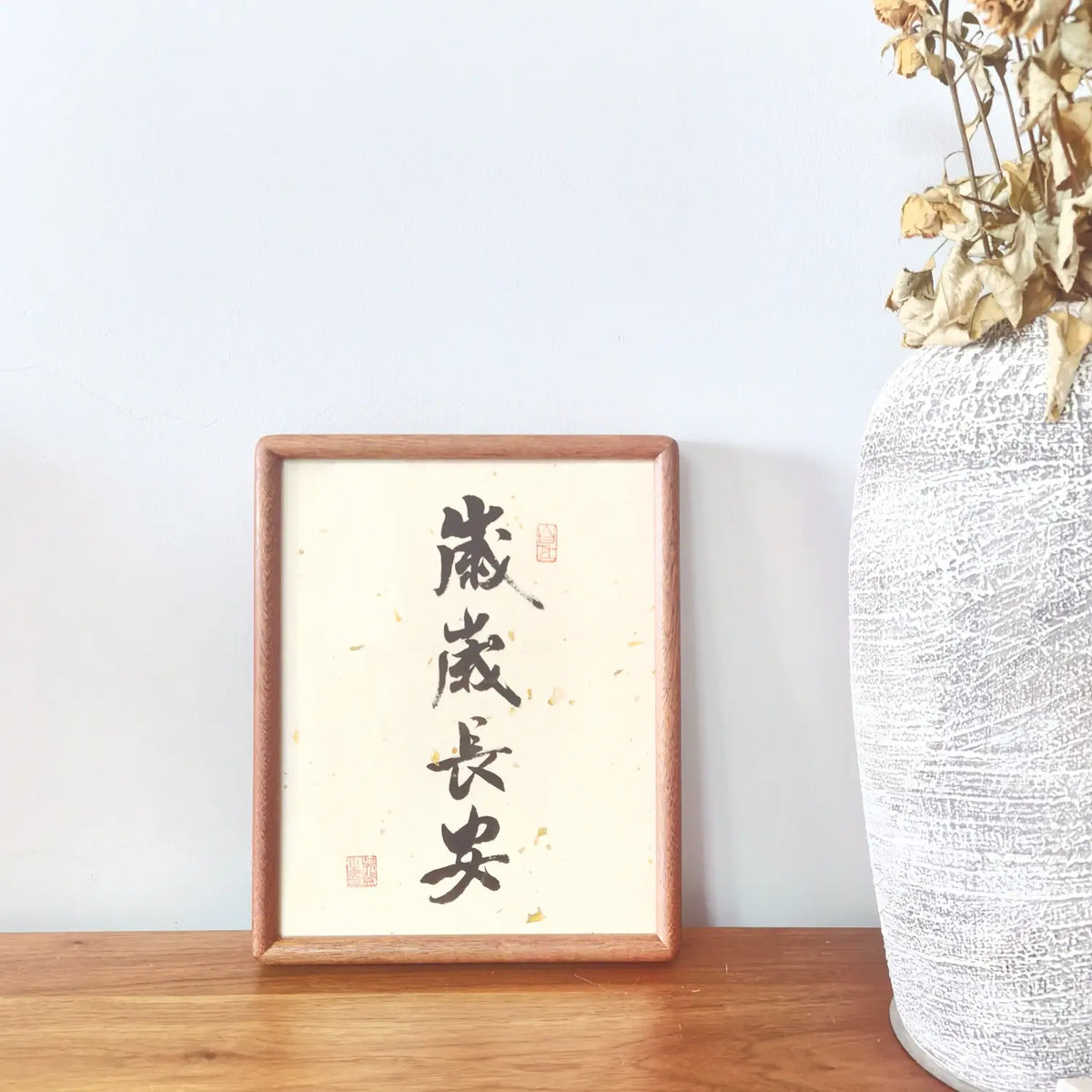 Handwritten Chinese calligraphy artwork featuring “岁岁长安” (Peace, Year After Year) in a solid ebony wood frame