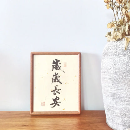 Handwritten Chinese calligraphy artwork featuring “岁岁长安” (Peace, Year After Year) in a solid ebony wood frame